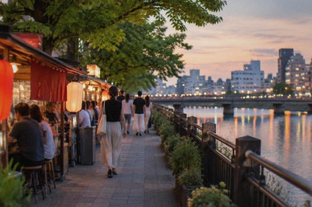 Summer evening along the Naka River with illuminated food stalls reflected in the water