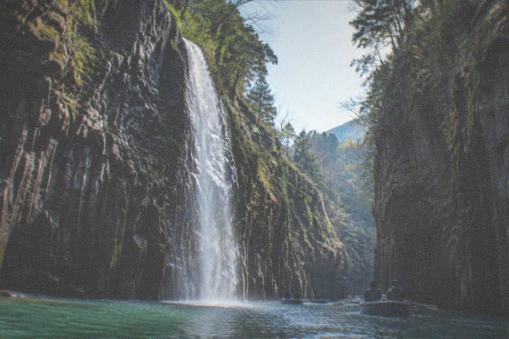 Verdant Takachiho Gorge with sheer cliffs and a calm turquoise river below