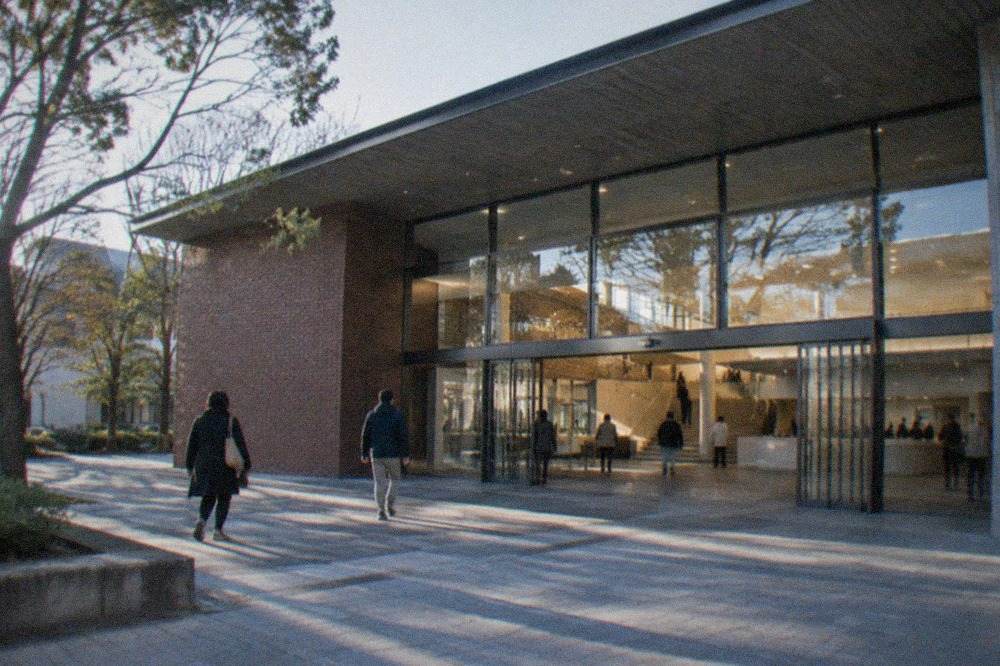 Bright modern museum lobby with a wide staircase and visitors information counter