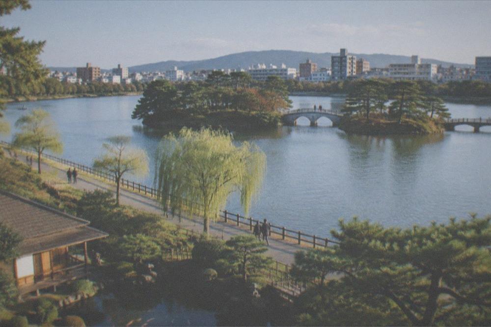 A small traditional garden with a koi pond and wooden tea house