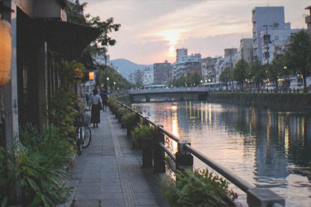 A quiet canal-side promenade at dusk with reflections on the water