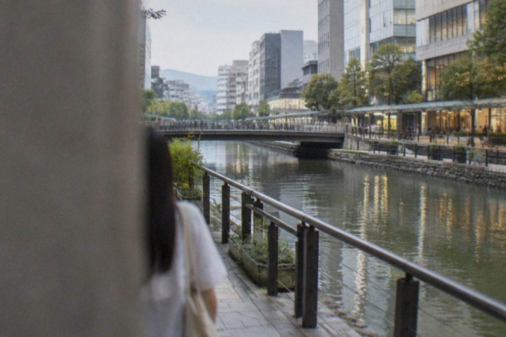 Wide canal running between shopping terraces with lit shopfronts reflected in the water