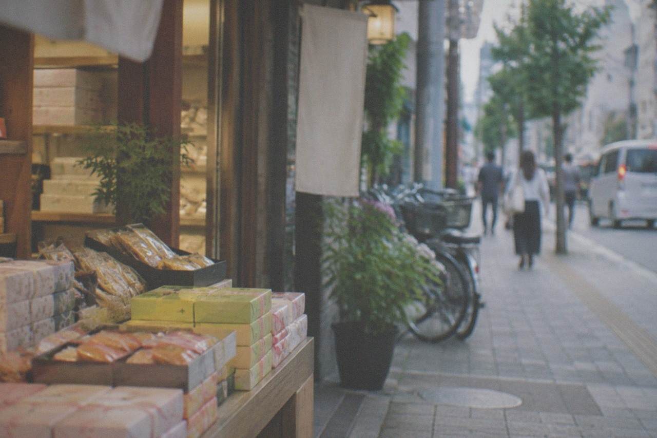 Shelves of packaged food gifts and wrapped boxes inside a brightly lit Japanese souvenir shop