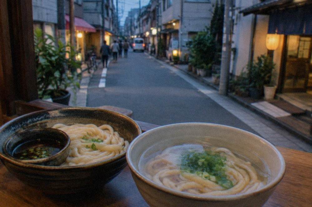 Two udon bowls side by side, one with firm pale noodles and dark dipping sauce, one with soft noodles in clear broth