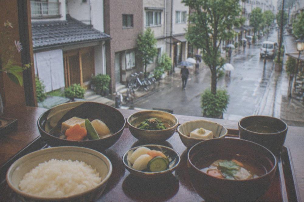 A formal plant-based temple meal in lacquer bowls with tofu, vegetables and rice arranged in courses
