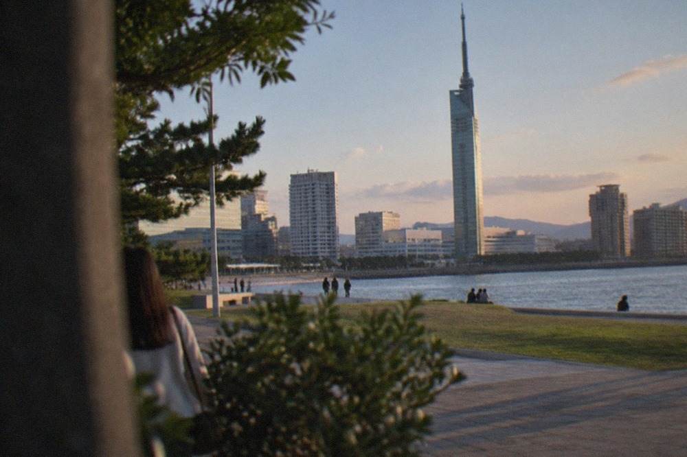 Fukuoka Tower standing over the Momochi waterfront with the city skyline behind it at dusk