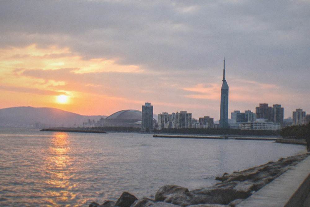 Sunset light over Hakata Bay seen from the Momochi shoreline with Fukuoka Tower in the distance