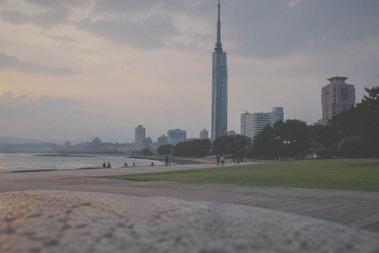 Fukuoka Tower standing over the Momochi waterfront with the city skyline behind it at dusk