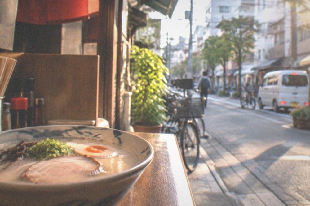 Bowl of tonkotsu ramen with chashu pork and a soft boiled egg on a wooden counter