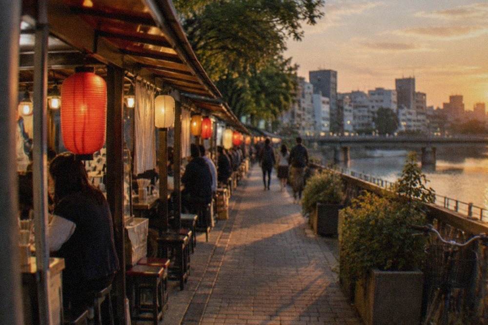 Illuminated food stalls lined along a river at night in a Japanese city