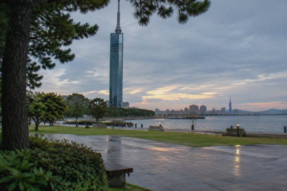 Hakata Bay waterfront at dusk with Fukuoka Tower lit in the distance