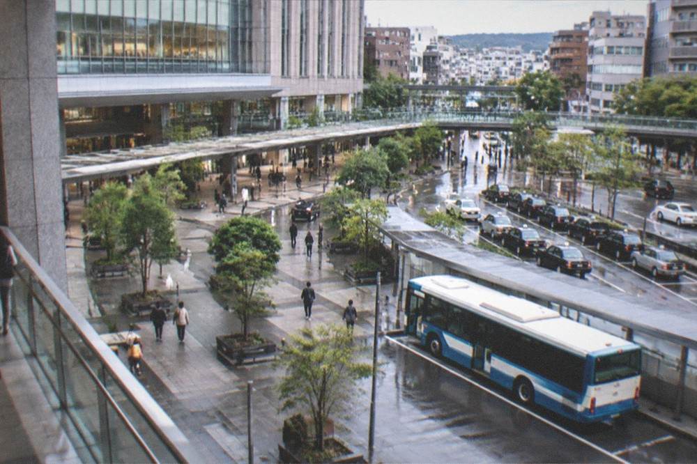 A clean modern subway platform with a blue and white train stopped at the doors about to open.