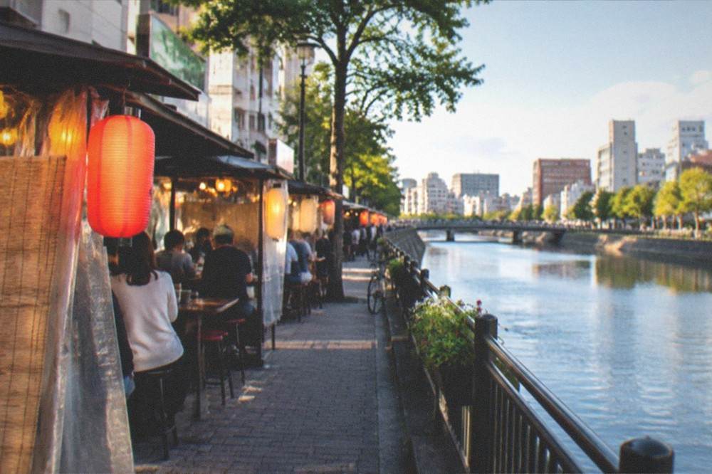 Illuminated riverside food stalls along the Naka River in Fukuoka at night