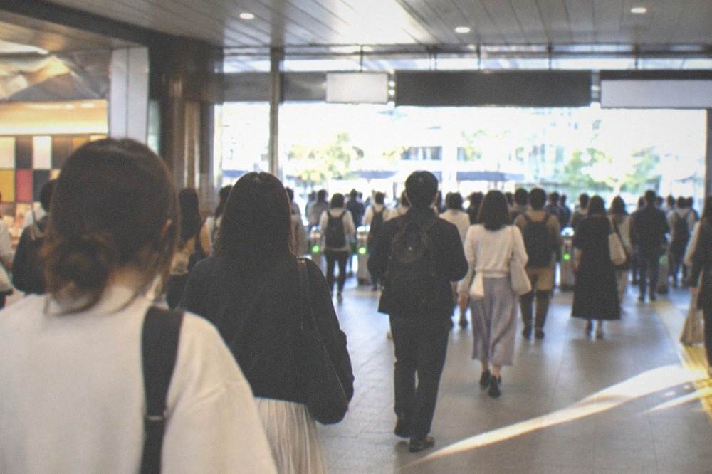 A subway station concourse with festival crowds moving toward the gates