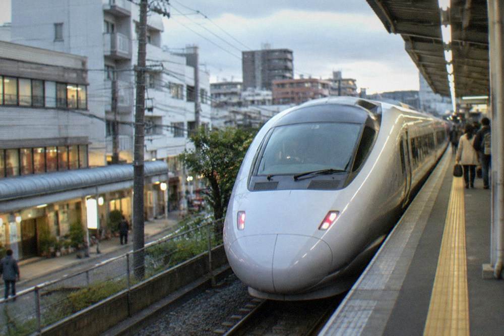 A train platform at dusk with a sleek express train waiting beside the platform