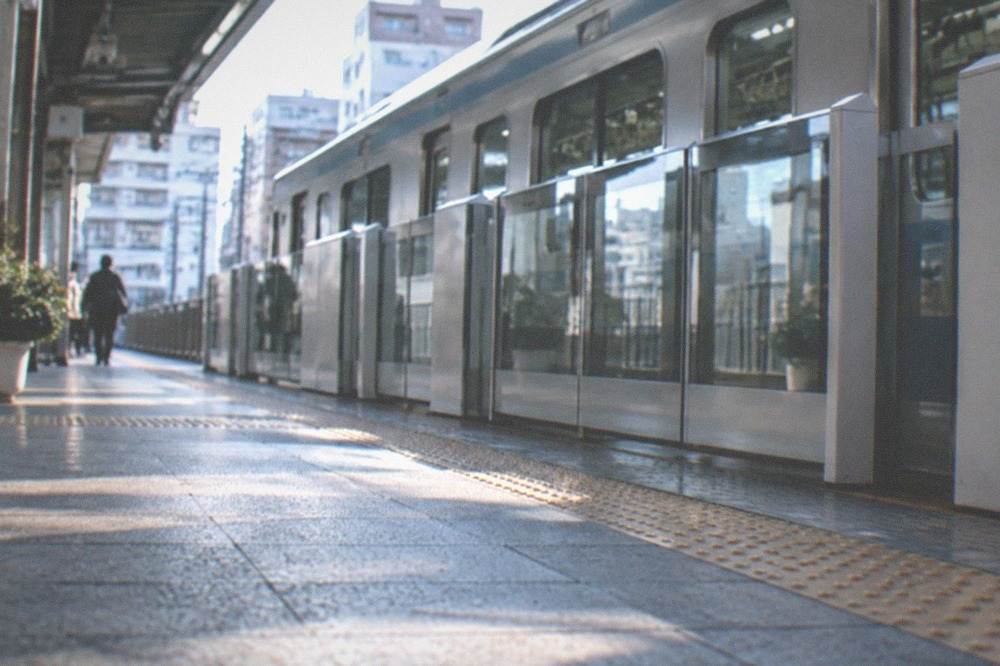 A subway platform with a sleek train stopped beside a row of platform screen doors