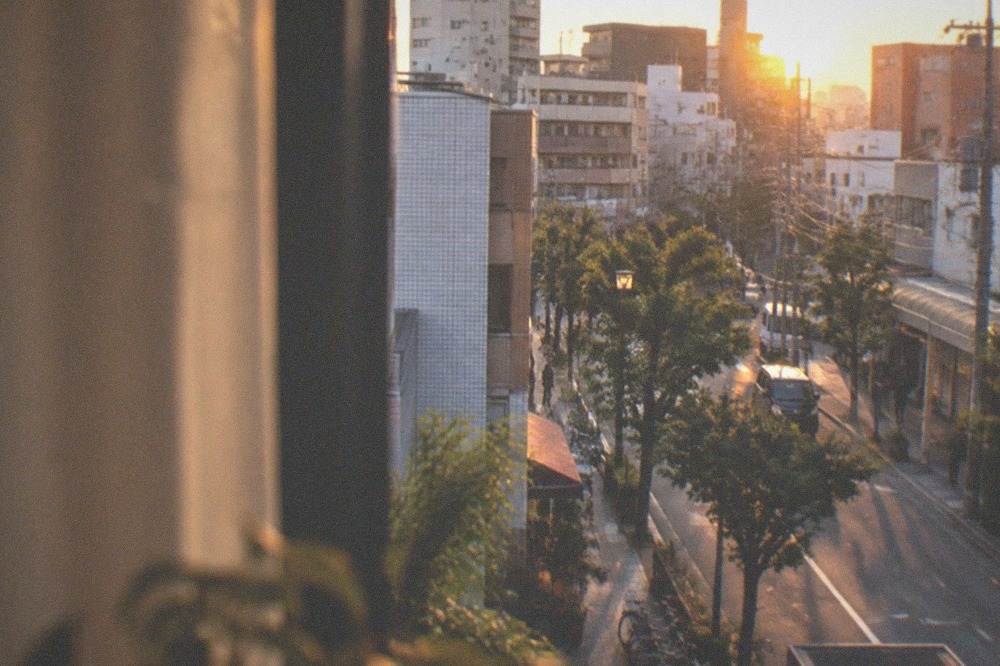 A hotel room window overlooking a city skyline at sunset