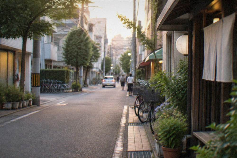 A quiet residential street with small shops and parked bicycles in the evening