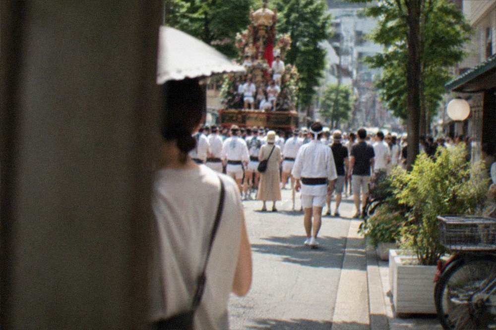 Festival floats and crowds filling a city street in Fukuoka during a summer celebration