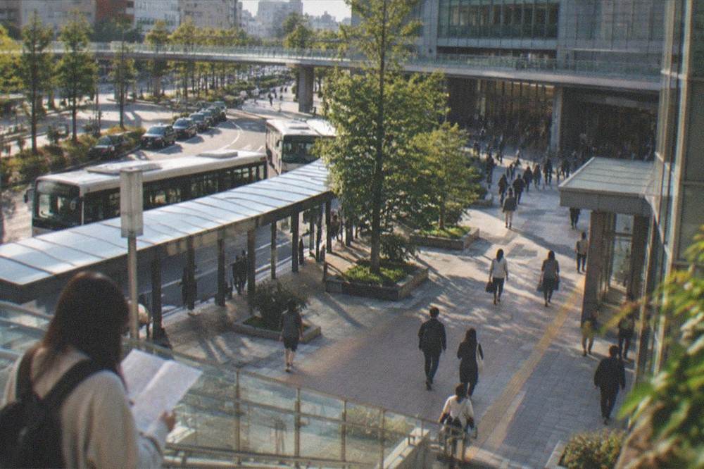 A traveller studying a route map on a station concourse beside ticket gates