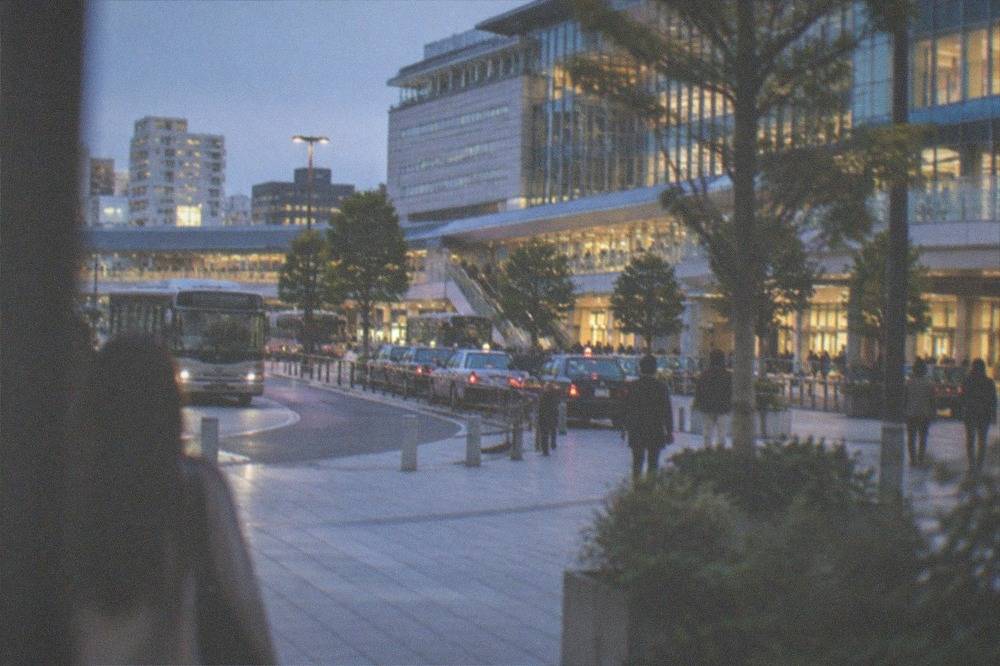 A clean subway platform with a silver train arriving and fare machines in the background