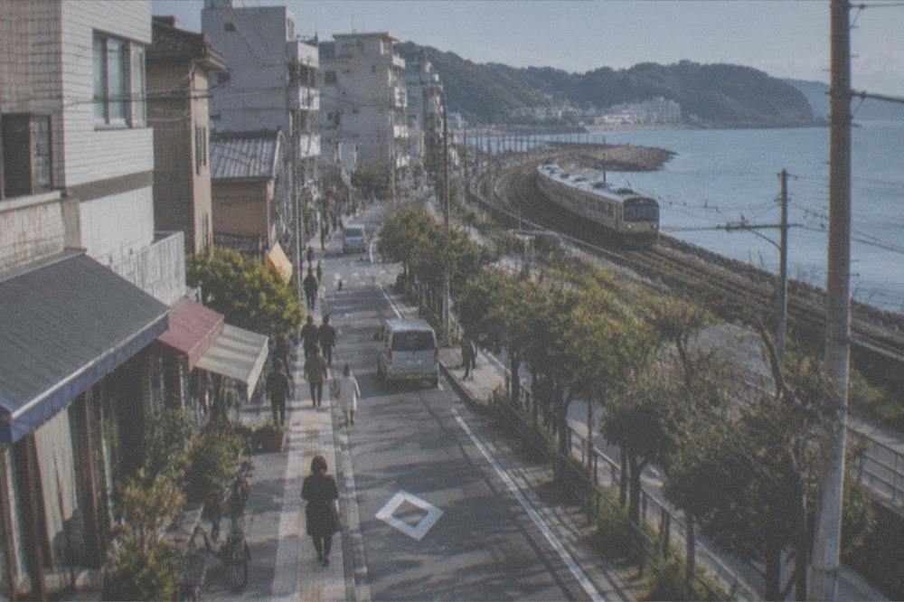 Coastal railway line curving along a green shoreline