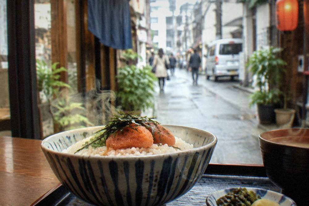 Steam rising from a rice bowl topped with a mentaiko sac in a small Fukuoka restaurant