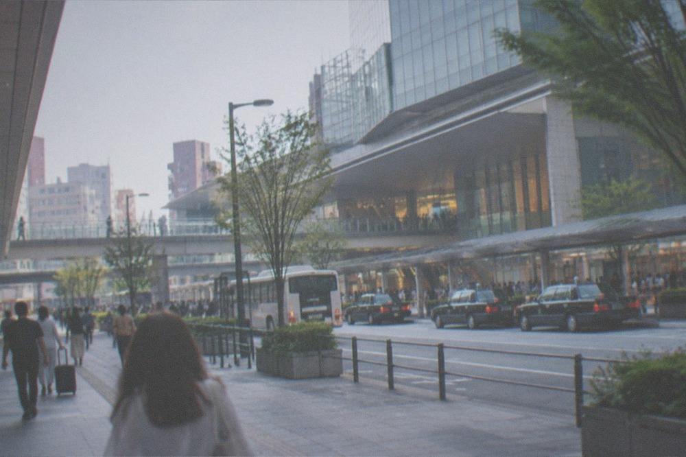 A busy station concourse with shops, signage and travellers moving through at dusk