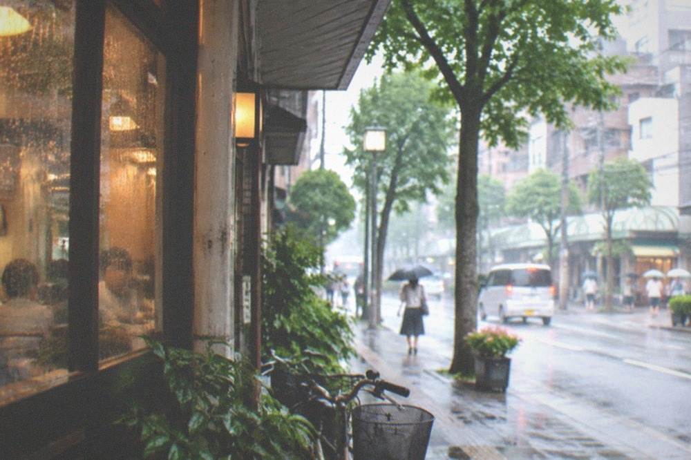 Rain-lashed windows of an indoor food hall with warm lighting inside