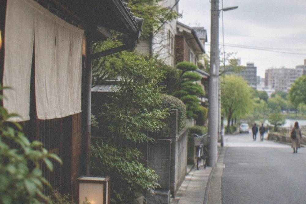 A quiet residential street with low buildings and greenery near Ohori Park