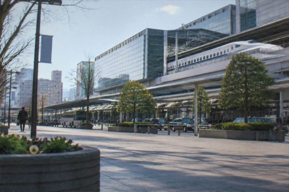 A Shinkansen bullet train at a platform beside a large station building