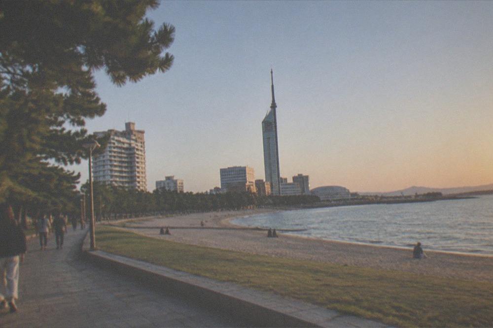 Fukuoka Tower rising above Momochi Seaside Park under a clear sky