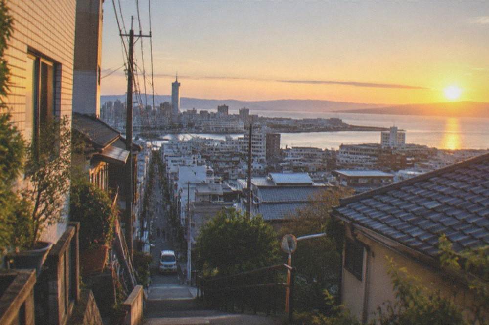 Sunset over Hakata Bay seen from a high viewpoint with the city skyline and water