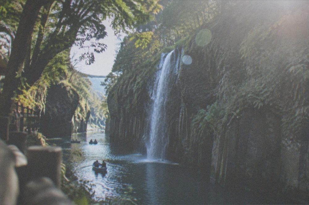 Columnar basalt cliffs of Takachiho Gorge with the Minainotaki waterfall dropping into the green river