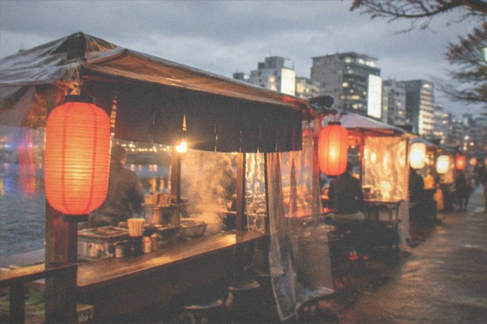 Yatai food stalls glowing along the Naka River in Nakasu at night