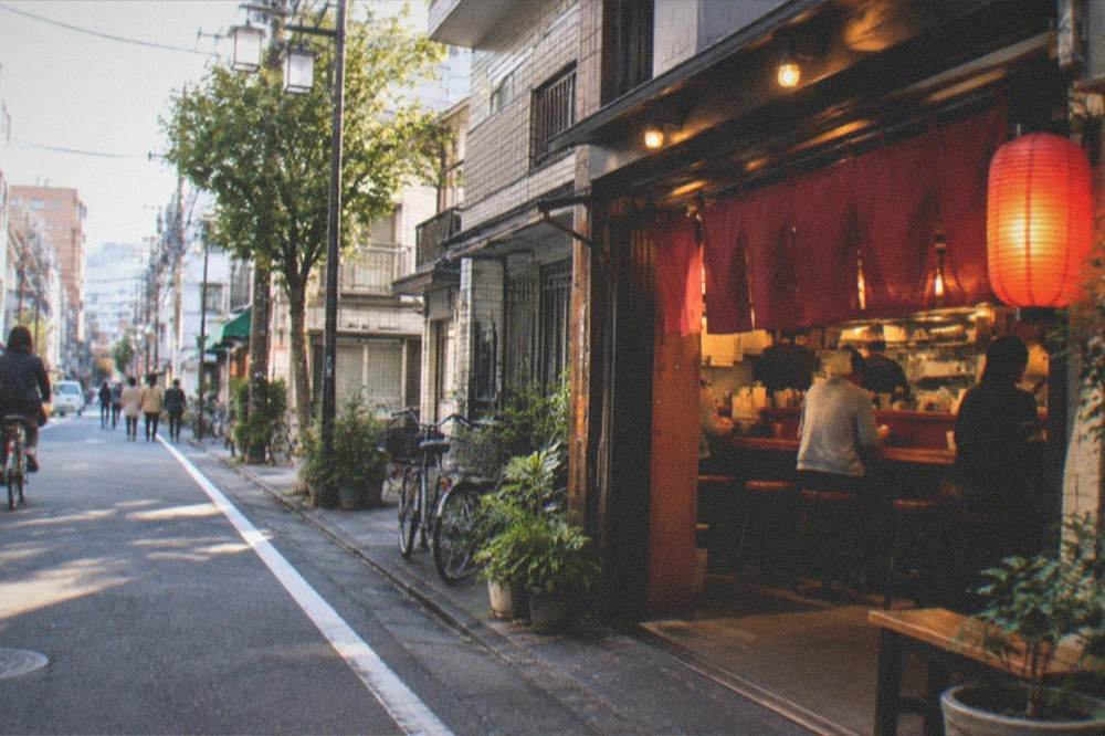 Small late-night ramen counter glowing with warm light on a quiet city street