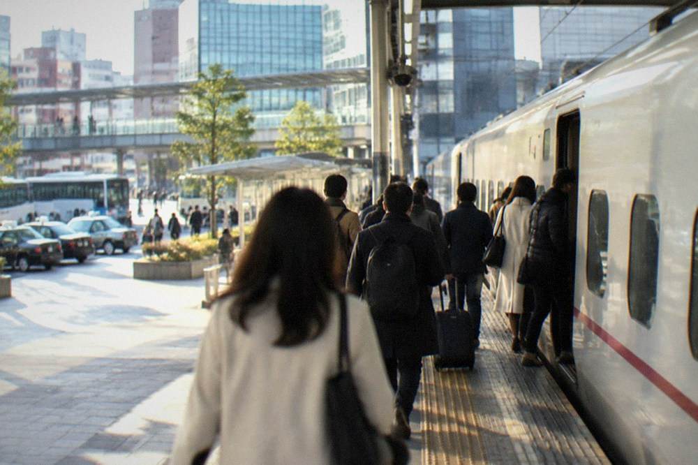 A limited express train standing at a platform in Hakata Station with passengers boarding