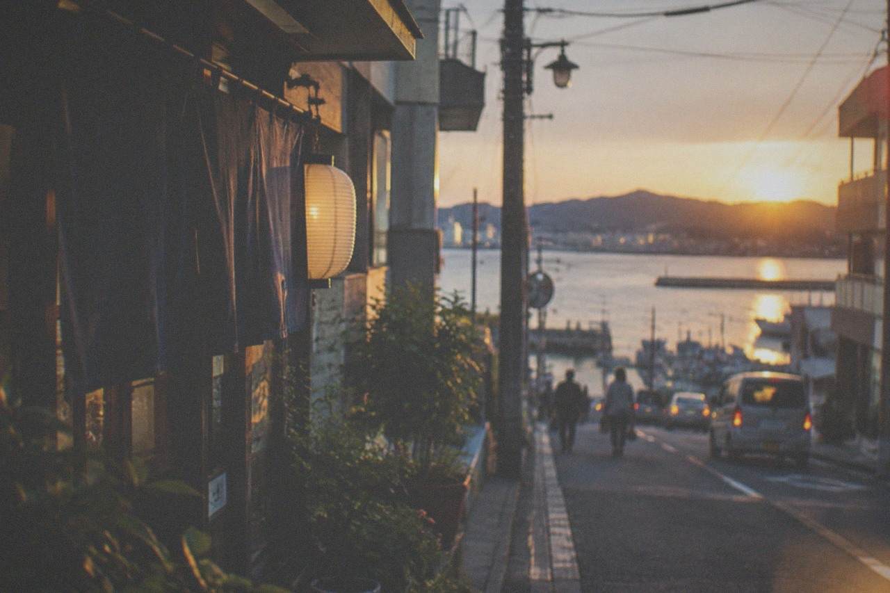 Hakata Bay at dusk with city lights reflecting on the water and hills across the bay